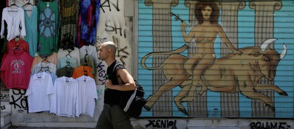 A pedestrian passes a graffiti depicting, the Greek mythological story about the abduction of the Phoenician maiden named Europa by the Olympian god Zeus in the form of a bull, in a symbolic depiction of what some see as the European crisis, at the shutter of a closed shop at Monastiraki tourist district in Athens, Monday, May 25, 2015 - Sputnik International
