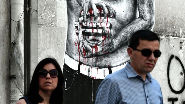 People pass by a graffiti showing a euro sign bleeding, in central Athens on July 14, 2015 - Sputnik International
