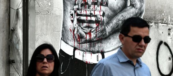 People pass by a graffiti showing a euro sign bleeding, in central Athens on July 14, 2015 People pass by a graffiti showing a euro sign bleeding, in central Athens on July 14, 2015 - Sputnik International