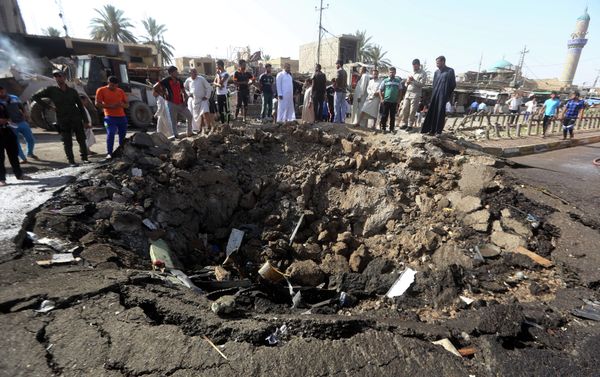 Iraqi men look at a crater left by a massive suicide car bomb attack carried out the previous day by the Islamic State group in the predominantly Shiite town of Khan Bani Saad, 20 km north of Baghdad, on July 18, 2015 Iraqi men look at a crater left by a massive suicide car bomb attack carried out the previous day by the Islamic State group in the predominantly Shiite town of Khan Bani Saad, 20 km north of Baghdad, on July 18, 2015 - Sputnik International