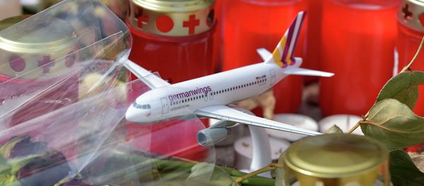 A model of a plane is placed between candles and flowers in front of the Germanwings headquarters in Cologne, western Germany for the victims of the plane crash two weeks ago in the French Alps, Tuesday, April 7, 2015 A model of a plane is placed between candles and flowers in front of the Germanwings headquarters in Cologne, western Germany for the victims of the plane crash two weeks ago in the French Alps, Tuesday, April 7, 2015 - Sputnik International