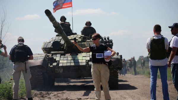 Members of OSCE Mission control the withdrawal of heavy weapons of independence supporters from the line of contact with Ukrainian forces near the western Ukrainian city of Donetsk on July 19, 2015 - Sputnik International
