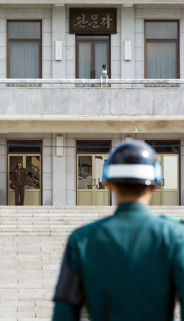 A South Korean JSA guard (front R) and North Korean guard (L) stand guard opposite each other at the border of the truce village of Panmunjom in the Demilitarized zone (DMZ) dividing the two Koreas. File photo. - Sputnik International