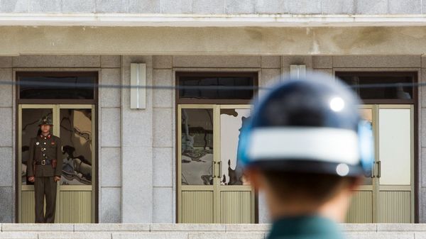 A South Korean JSA guard (front R) and North Korean guard (L) stand guard opposite each other at the border of the truce village of Panmunjom in the Demilitarized zone (DMZ) dividing the two Koreas. File photo. - Sputnik International