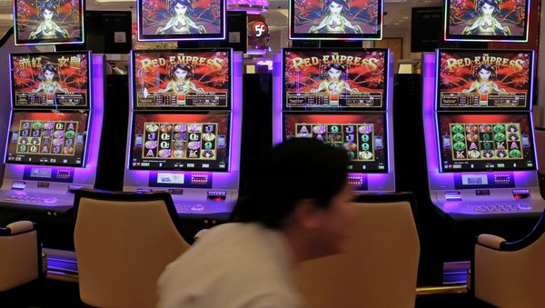 A worker walks past slot machines - Sputnik International
