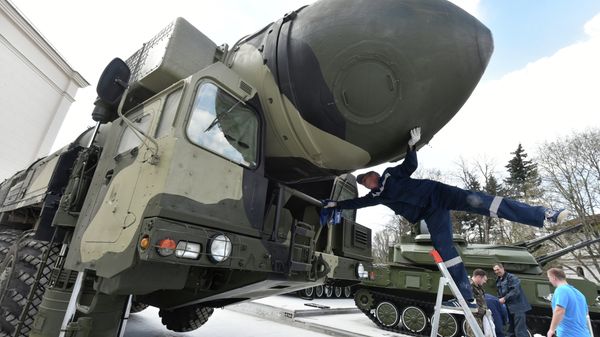 An employee cleans a Topol-M intercontinental ballistic missile launcher at an open-air military exhibition in Moscow on April 29, 2015 - Sputnik International