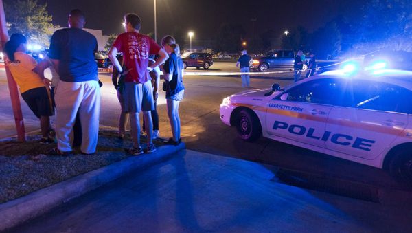 Bystanders watch over the scene at a movie theatre where a man opened fire on film goers in Lafayette, Louisiana July 23, 2015 - Sputnik International