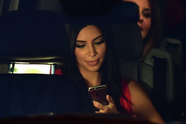 US reality TV star Kim Kardashian looks at her iPhone as she sits in a car after visiting the genocide memorial, which commemorates the 1915 mass killing of Armenians in the Ottoman Empire, in Yerevan on April 10, 2015 - Sputnik International