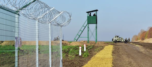 Urkainian border guards stand near an Armoured Personnel Carrier (APCs) parked near a newly constructed part of the border near the Goptivka border crossing on the Urkainian-Russian border, north of Kharkiv, eastern Ukraine, on October 15, 2014 - Sputnik International