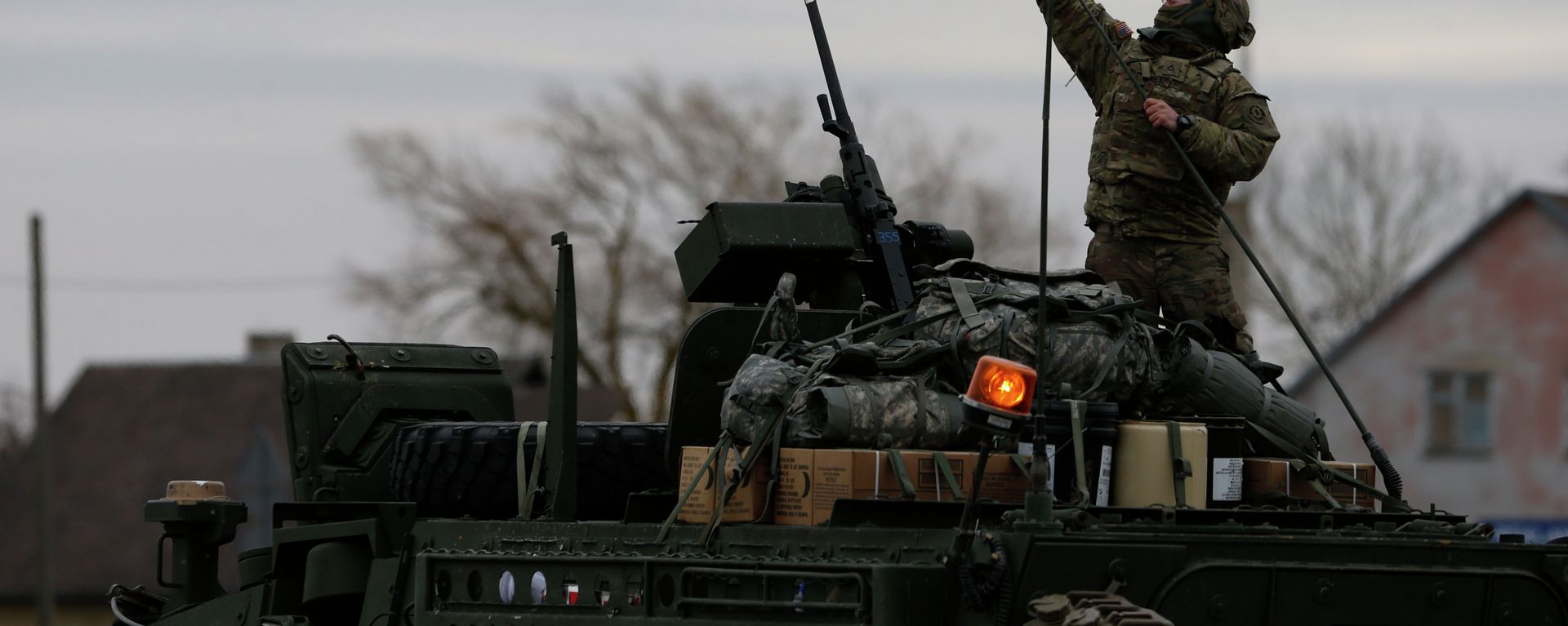 A member of US Army’s 2nd Cavalry Regiment raises the US flag on a Stryker vehicle during the ''Dragoon Ride'' military exercise, in Salociai some 178 kms (110 miles) north of the capital Vilnius, Lithuania, Monday, March 23, 2015 - Sputnik International, 1920, 08.04.2025