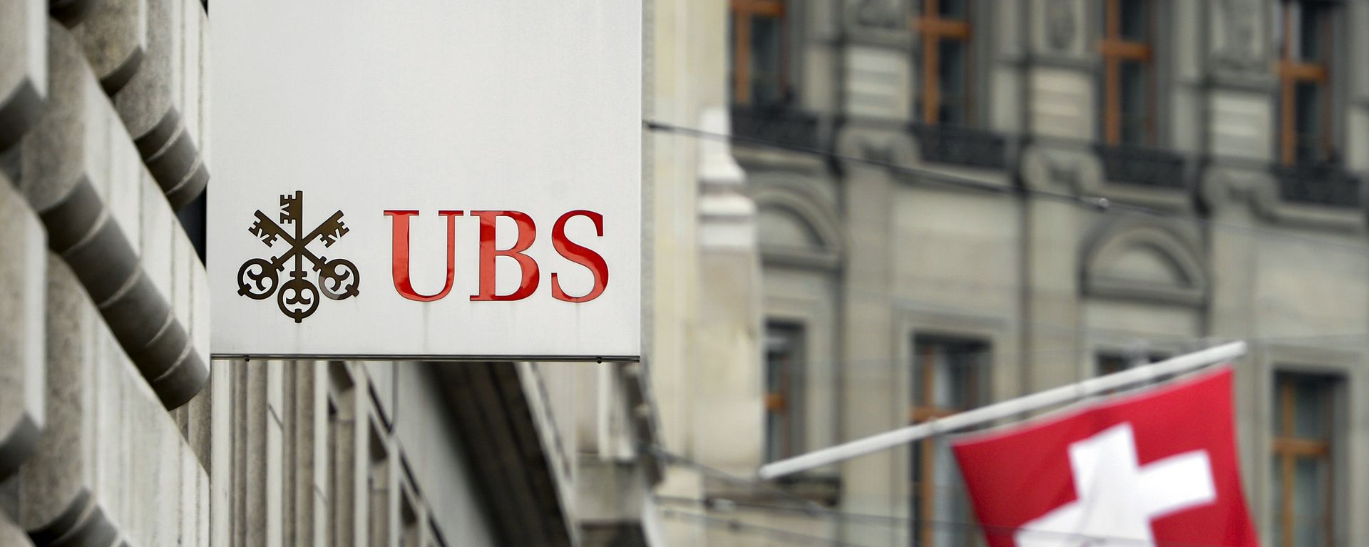 A Swiss flag is seen behind a sign of Swiss bank giant UBS on June 11, 2013 in Basel. - Sputnik International, 1920, 19.03.2023