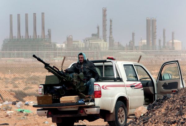 In this March 5, 2011 file photo, an anti-government rebel sits with an anti-aircraft weapon in front an oil refinery, after the capture of the oil town of Ras Lanouf, eastern Libya. - Sputnik International