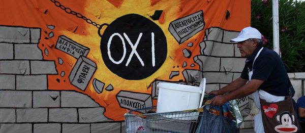 A street vendor pushes his trolley as he passes a banner, depicting a wrecking ball that reads: NO and destroying a wall with anti-austerity measures, in Athens, Wednesday, July 22, 2015. - Sputnik International