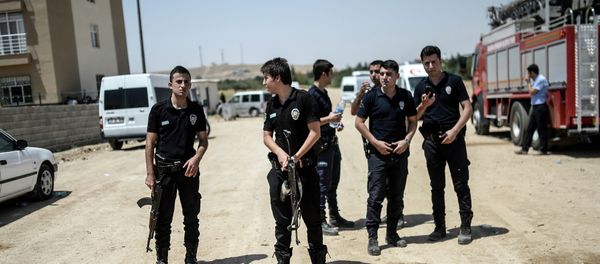 Turkish police stand near a building, where two police officers were found shot dead at their home on July 22, 2015 in the Turkish town of Ceylanpinar on the border with Syria - Sputnik International