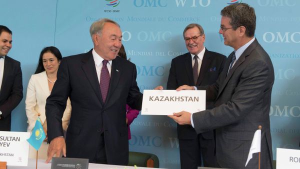 WTO Director general Roberto Azevedo (R) offers Kazakhstan's country sign to President Nursultan Nazarbayev after the accession ceremony at the World Trade Organization (WTO) headquarters in Geneva, Switzerland July 27, 2015 - Sputnik International