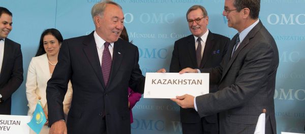 WTO Director general Roberto Azevedo (R) offers Kazakhstan's country sign to President Nursultan Nazarbayev after the accession ceremony at the World Trade Organization (WTO) headquarters in Geneva, Switzerland July 27, 2015 - Sputnik International