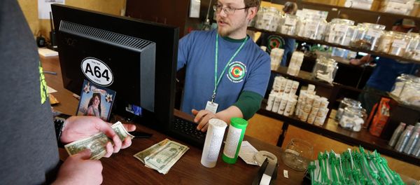 In this May 8, 2014 file photo, a customer pays cash for retail marijuana at 3D Cannabis Center, in Denve In this May 8, 2014 file photo, a customer pays cash for retail marijuana at 3D Cannabis Center, in Denve - Sputnik International