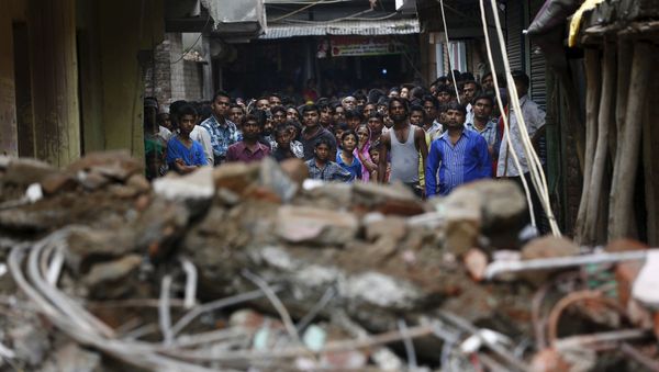 Onlookers stand at the site of a collapsed building Onlookers stand at the site of a collapsed building - Sputnik International