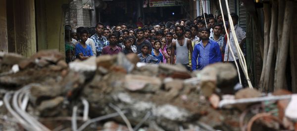 Onlookers stand at the site of a collapsed building Onlookers stand at the site of a collapsed building - Sputnik International