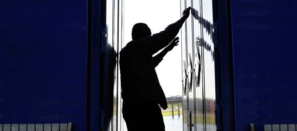 A migrant stands between two trailers of a lorry as he attempts to cross the English Channel, A migrant stands between two trailers of a lorry as he attempts to cross the English Channel, - Sputnik International