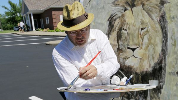 Mark Balma works on a mural of Cecil the lion outside Dr. Walter James Palmer's dental office in Bloomington, Minnesota. Mark Balma works on a mural of Cecil the lion outside Dr. Walter James Palmer's dental office in Bloomington, Minnesota. - Sputnik International