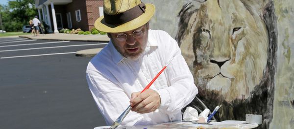 Mark Balma works on a mural of Cecil the lion outside Dr. Walter James Palmer's dental office in Bloomington, Minnesota. Mark Balma works on a mural of Cecil the lion outside Dr. Walter James Palmer's dental office in Bloomington, Minnesota. - Sputnik International