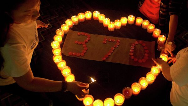Relatives of Chinese passengers on board the Malaysia Airlines Flight MH370 light candles in a prayer room in Beijing, China, Friday, April 4, 2014. - Sputnik International