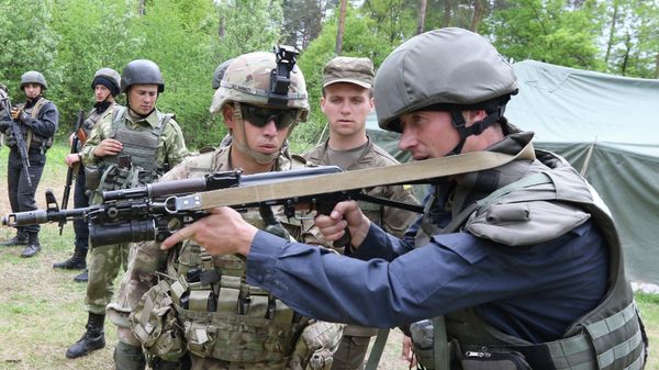 US soldier, left, instructs a Ukrainian soldier during joint training exercises on the military base in the Lviv region. US soldier, left, instructs a Ukrainian soldier during joint training exercises on the military base in the Lviv region. - Sputnik International