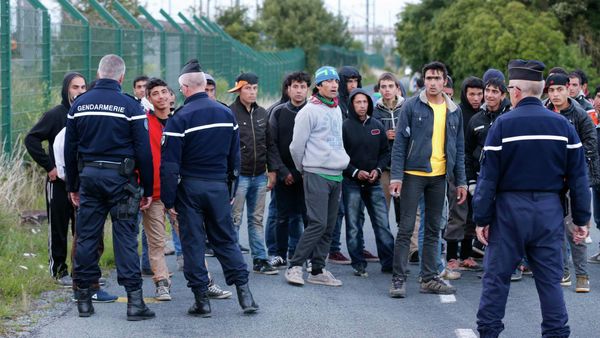 French gendarmes block migrants along a road to prevent them access to train tracks which lead to the Channel Tunnel in Frethun, near Calais, France French gendarmes block migrants along a road to prevent them access to train tracks which lead to the Channel Tunnel in Frethun, near Calais, France - Sputnik International
