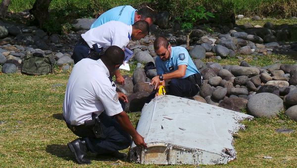 French gendarmes and police inspect a large piece of plane debris which was found on the beach in Saint-Andre. - Sputnik International