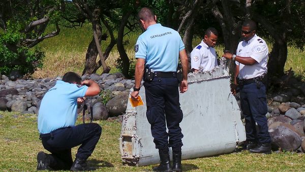 French gendarmes and police inspect a large piece of plane debris which was found on the beach in Saint-Andre - Sputnik International