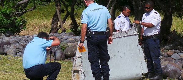 French gendarmes and police inspect a large piece of plane debris which was found on the beach in Saint-Andre - Sputnik International