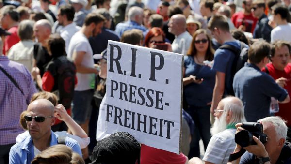 A demonstrator holds up a placard which reads Rest in Peace freedom of press! during a rally to protest against a criminal complaint by the domestic intelligence agency A demonstrator holds up a placard which reads Rest in Peace freedom of press! during a rally to protest against a criminal complaint by the domestic intelligence agency - Sputnik International