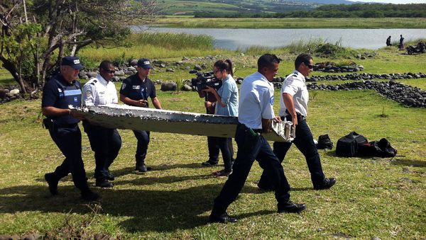 Police carry a piece of debris from an unidentified aircraft found in the coastal area of Saint-Andre de la Reunion, in the east of the French Indian Ocean island of La Reunion, on July 29, 2015 Police carry a piece of debris from an unidentified aircraft found in the coastal area of Saint-Andre de la Reunion, in the east of the French Indian Ocean island of La Reunion, on July 29, 2015 - Sputnik International