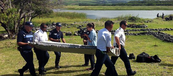 Police carry a piece of debris from an unidentified aircraft found in the coastal area of Saint-Andre de la Reunion, in the east of the French Indian Ocean island of La Reunion, on July 29, 2015 - Sputnik International