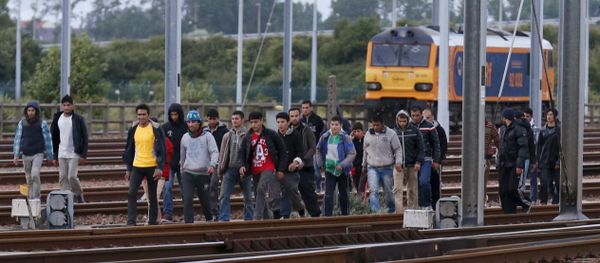 Migrants make their way along train tracks as they attempt to access the Channel Tunnel in Frethun, near Calais, France, July 29, 2015 Migrants make their way along train tracks as they attempt to access the Channel Tunnel in Frethun, near Calais, France, July 29, 2015 - Sputnik International