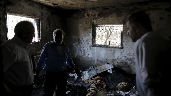 Palestinians inspect a house which was set on fire in a suspected attack by Jewish extremists in Duma village near the West Bank city of Nablus - Sputnik International