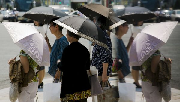 Women hold parasols as they wait at a pedestrian crossing on a hot day in Tokyo - Sputnik International