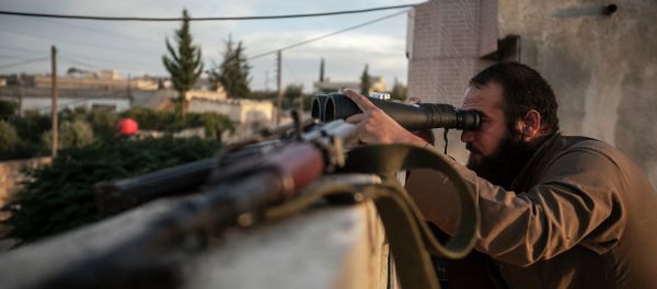 In this Thursday, Sept. 19, 2013 photo, a Syrian opposition fighter watches over as heavy fighting breaks out in in the Idlib province countryside, Syria - Sputnik International