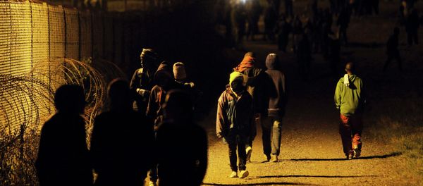 Migrants walk along a fence outside the Eurotunnel area, in Calais, northern France, July 29, 2015 Migrants walk along a fence outside the Eurotunnel area, in Calais, northern France, July 29, 2015 - Sputnik International