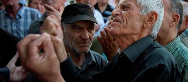 Elderly people argue with a bank worker as they wait to be allowed into the bank to withdraw a maximum of 120 euros ($134) for the week in Athens, Monday, July 6, 2015. - Sputnik International