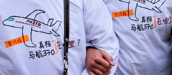 Relatives of passengers on board the Malaysia Airlines Flight 370 that went missing on March 8, 2014, wearing T-shirts carrying a message for the missing flight as they leave Yonghegong Lama Temple after a gathering of family members of the missing passengers, in Beijing Sunday, March 8, 2015. - Sputnik International