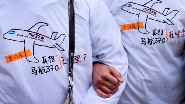 Relatives of passengers on board the Malaysia Airlines Flight 370 that went missing on March 8, 2014, wearing T-shirts carrying a message for the missing flight as they leave Yonghegong Lama Temple after a gathering of family members of the missing passengers, in Beijing Sunday, March 8, 2015. Relatives of passengers on board the Malaysia Airlines Flight 370 that went missing on March 8, 2014, wearing T-shirts carrying a message for the missing flight as they leave Yonghegong Lama Temple after a gathering of family members of the missing passengers, in Beijing Sunday, March 8, 2015. - Sputnik International