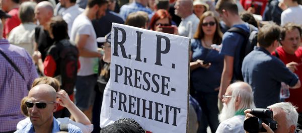A demonstrator holds up a placard which reads Rest in Peace freedom of press! during a rally to protest against a criminal complaint by the domestic intelligence agency, the Office for the Protection of the Constitution (BfV), over articles about it that appeared on the Netzpolitik.org blog, in Berlin, Germany, August 1, 2015 - Sputnik International