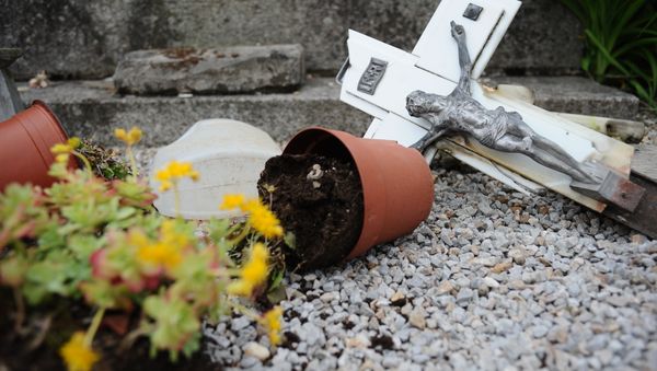 A photo taken on April 15, 2015 shows a damaged crucifix on the ground after tombstones were found vandalized at the Saint-Roch cemetery in Castres, southern France - Sputnik International