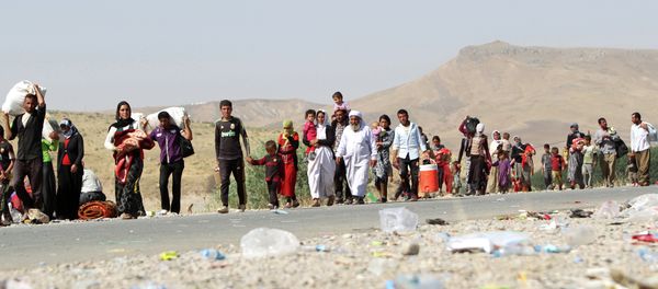 A file picture taken on August 13, 2014, shows displaced Iraqi families from the Yazidi community crossing the Iraqi-Syrian border at the Fishkhabur crossing, in northern Iraq - Sputnik International