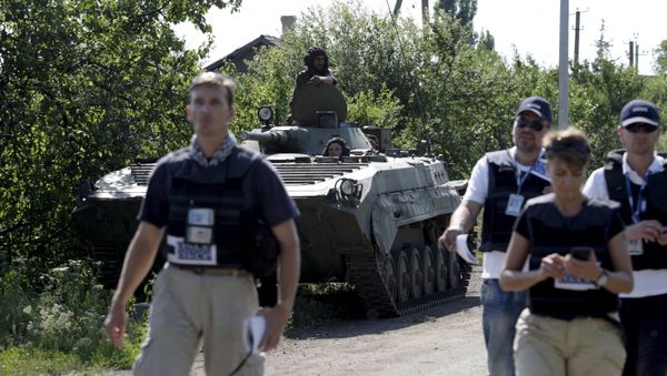 Members of the Organisation for Security and Co-operation in Europe (OSCE) walk past an armoured personnel carrier (APC) of the self-proclaimed Donetsk People's Republic forces outside the village of Novolaspa in Donetsk region, Ukraine, July 19, 2015 Members of the Organisation for Security and Co-operation in Europe (OSCE) walk past an armoured personnel carrier (APC) of the self-proclaimed Donetsk People's Republic forces outside the village of Novolaspa in Donetsk region, Ukraine, July 19, 2015 - Sputnik International