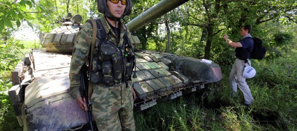 A member of the Organisation for Cooperation and Security in Europe (OSCE) Mission poses on a tank as he and others control the withdrawal of heavy weapons from independence supporters at the line of contact with Ukrainian forces, near Donetsk on July 19, 2015 A member of the Organisation for Cooperation and Security in Europe (OSCE) Mission poses on a tank as he and others control the withdrawal of heavy weapons from independence supporters at the line of contact with Ukrainian forces, near Donetsk on July 19, 2015 - Sputnik International