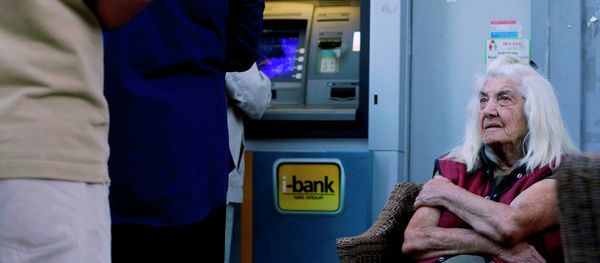 A pensioner looks at customers who use an ATM as she sits outside a bank in Athens, Wednesday, July 1, 2015. A pensioner looks at customers who use an ATM as she sits outside a bank in Athens, Wednesday, July 1, 2015. - Sputnik International