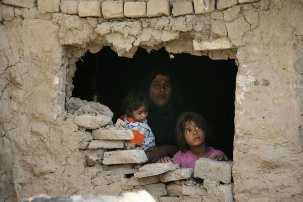 Iraqi family stands inside their home hit by an airstrike in Fidhailiya area in eastern Baghdad, Iraq. - Sputnik International